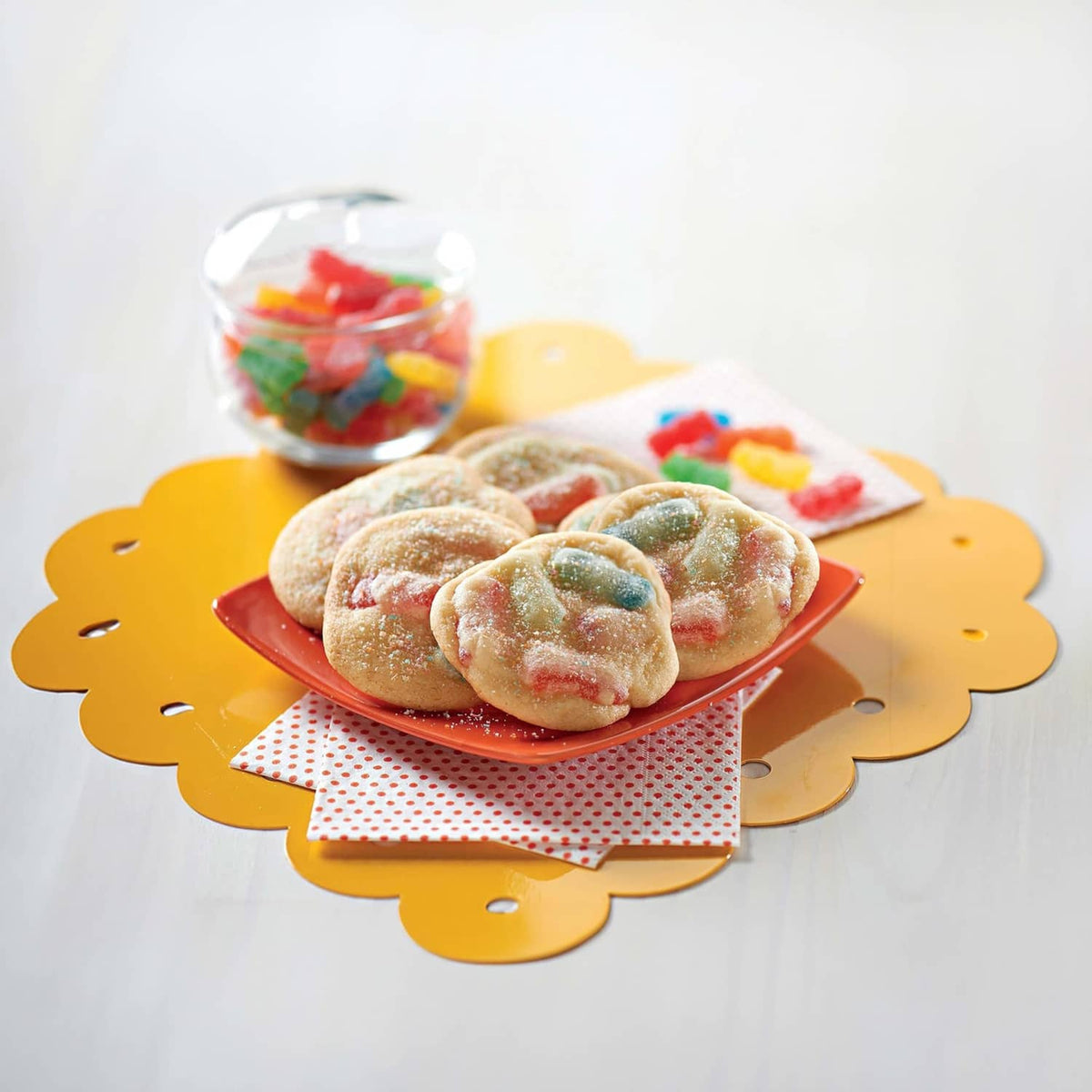 Sugar-coated gummy candy snacks on a bright orange plate