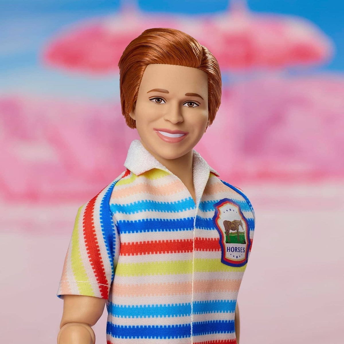 Collectible doll close-up wearing a rainbow striped shirt with a patch and collared neckline