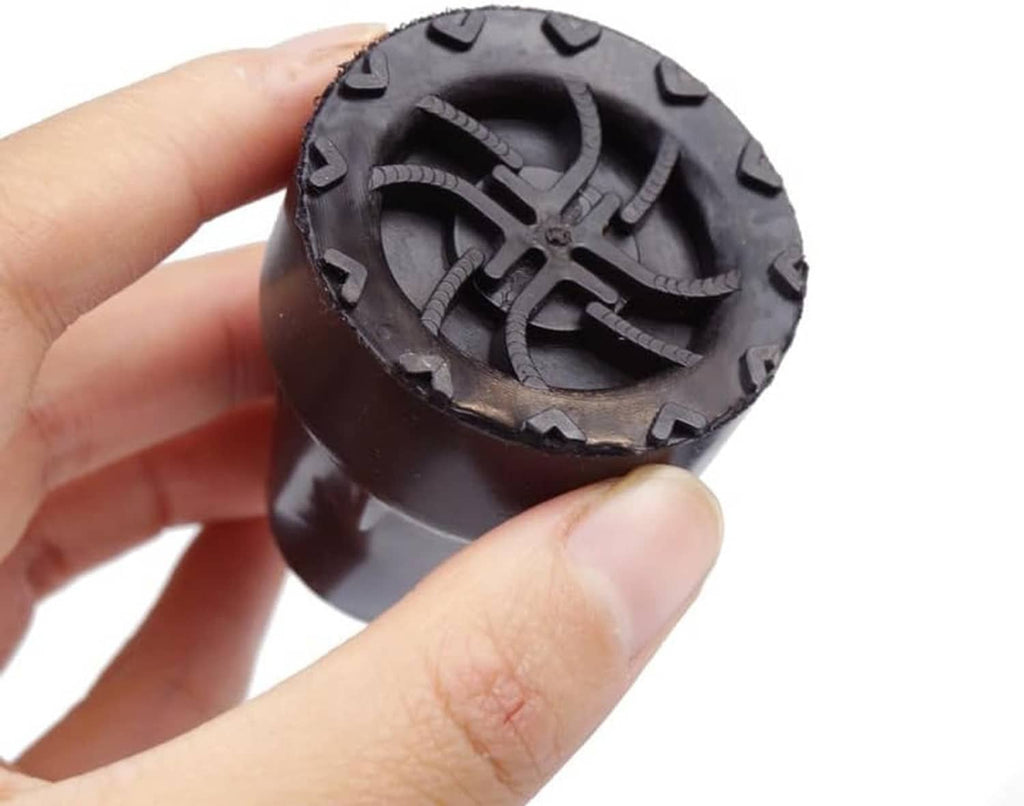 Crutch tip rubber end cap held in hand, black with circular tread pattern