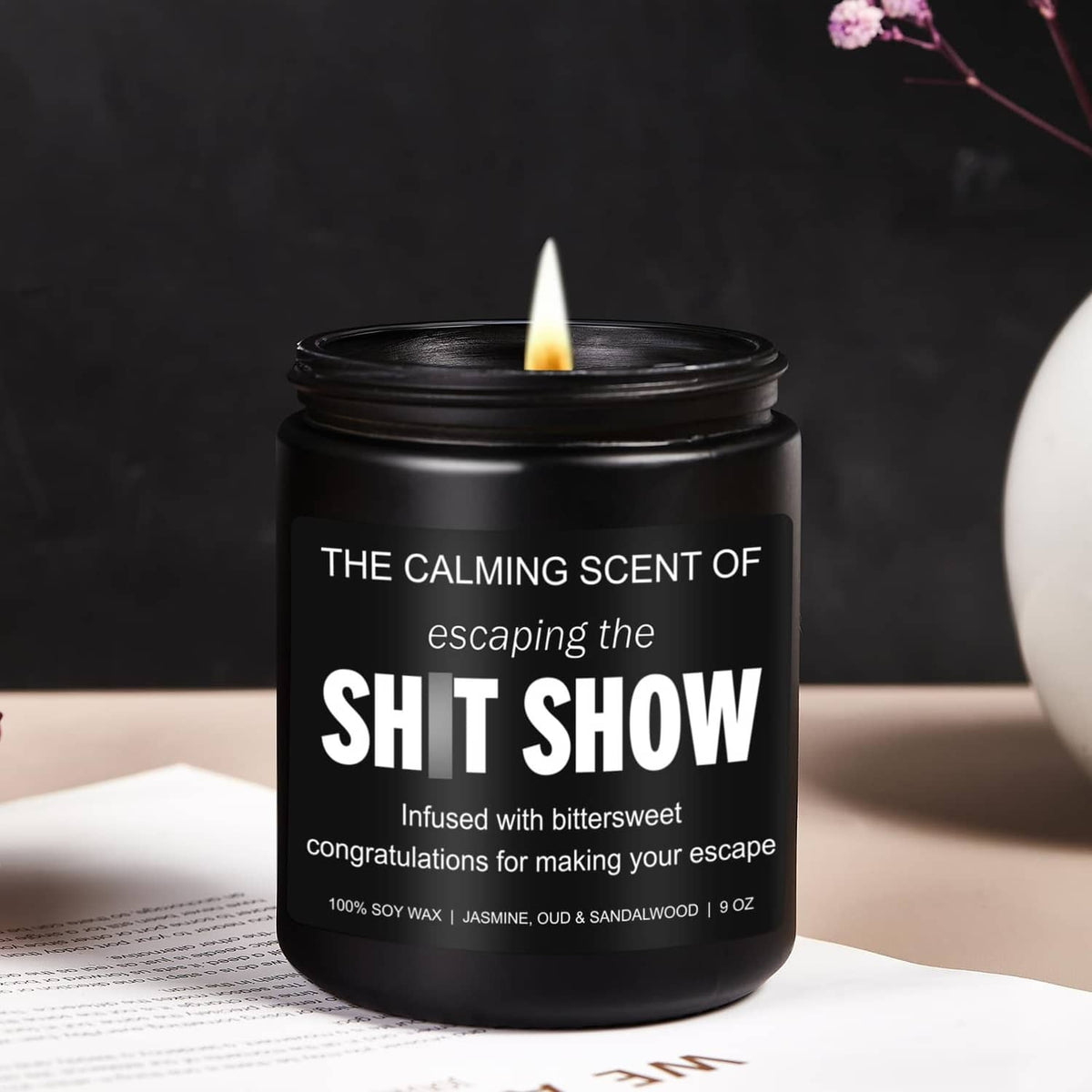 Black jar candle with lit wick and bold white label; soy wax, 9 oz.