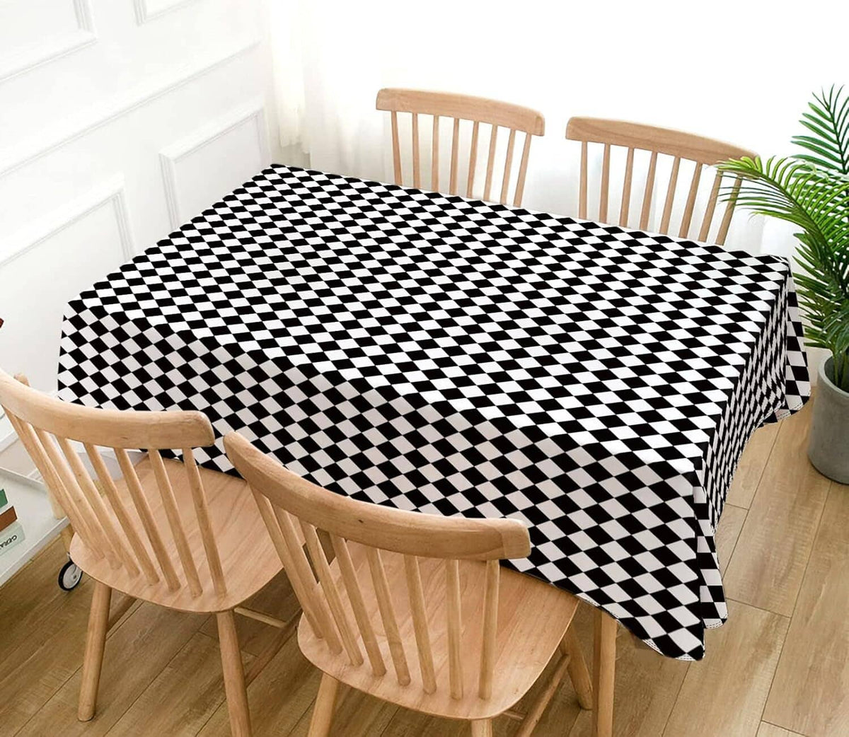 Black and white diamond check tablecloth on a dining table with chairs