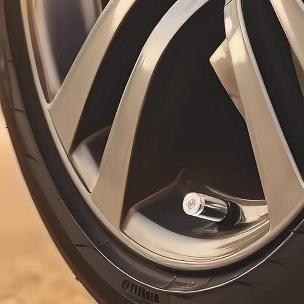Nickel bullet-shaped tire valve stem cap with black insert on a car wheel