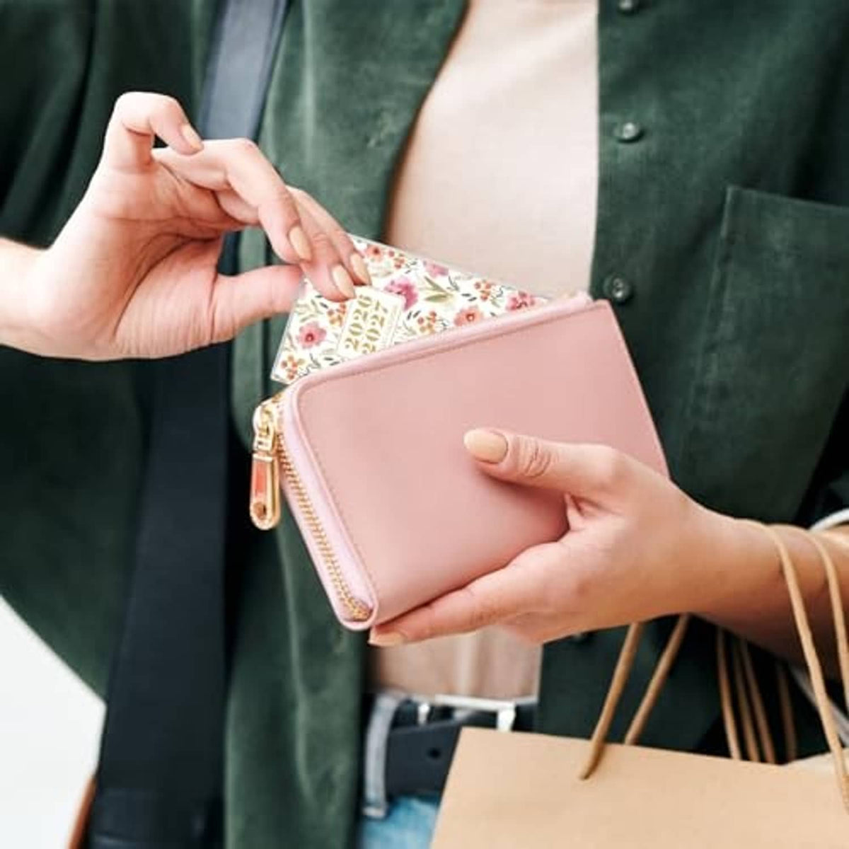 Floral pocket calendar wallet with zip closure held in hands