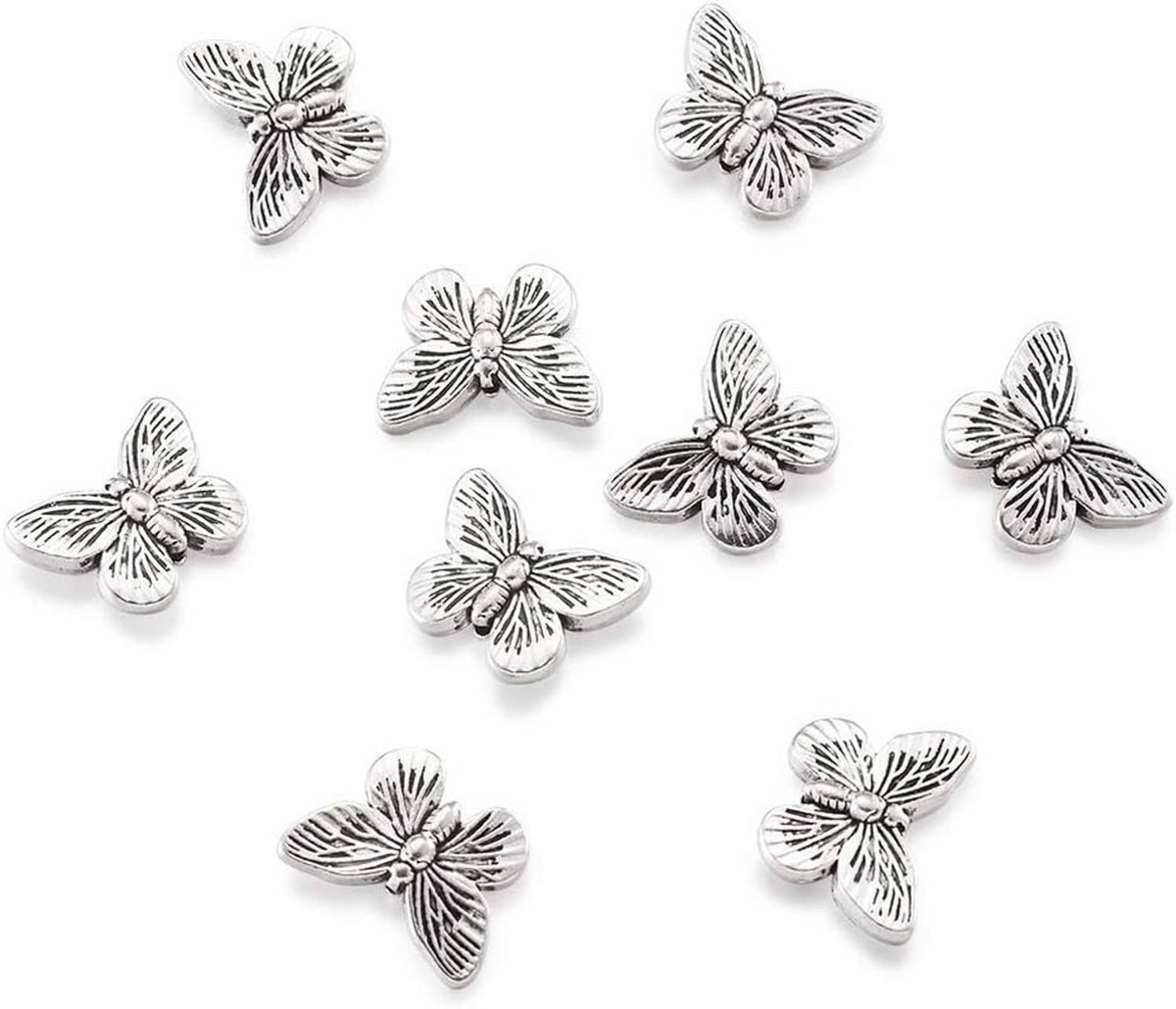 Antique silver butterfly spacer beads arranged on a white background, metal pieces