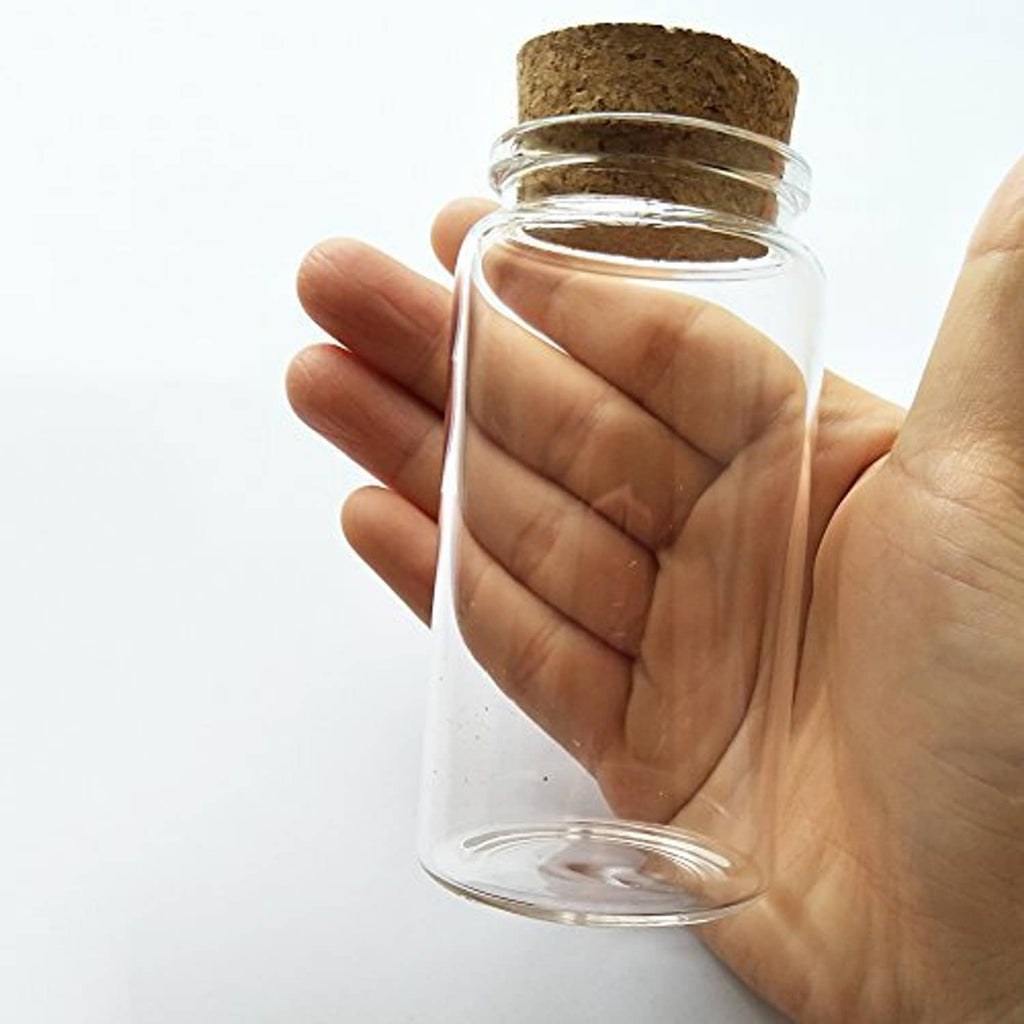 Small clear glass bottle vial with cork stopper, held at angle, cylindrical shape