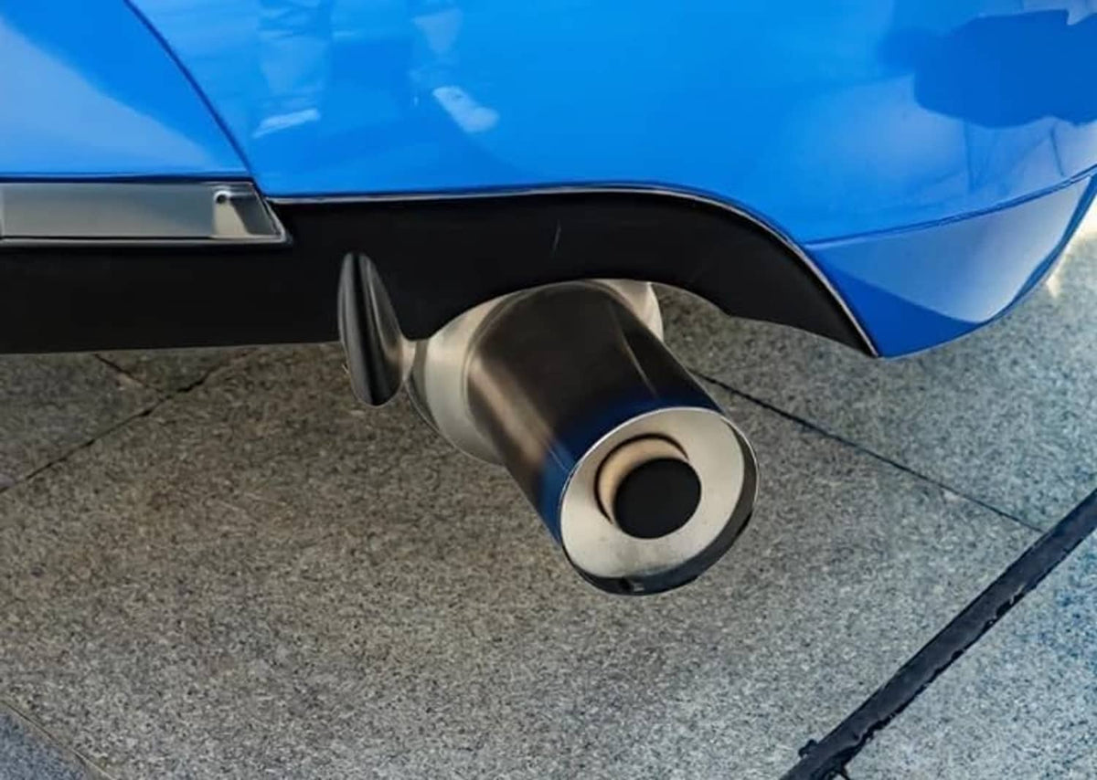 Installed exhaust muffler tip with downward round outlet and black inner insert