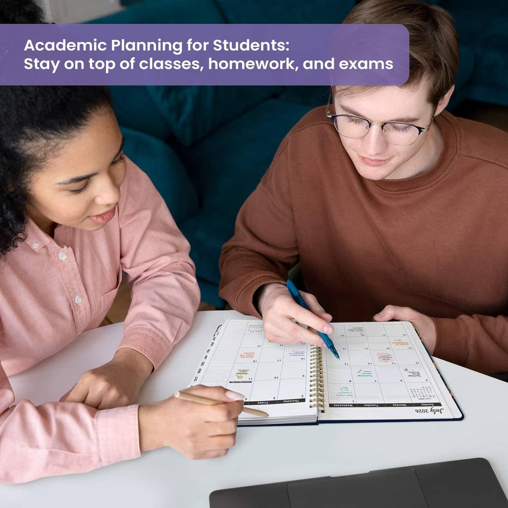 Academic planner on desk as two students write in the open monthly calendar