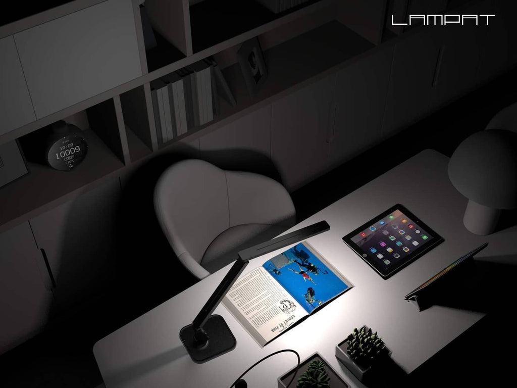 Black LED desk lamp casting light on a tablet and open book
