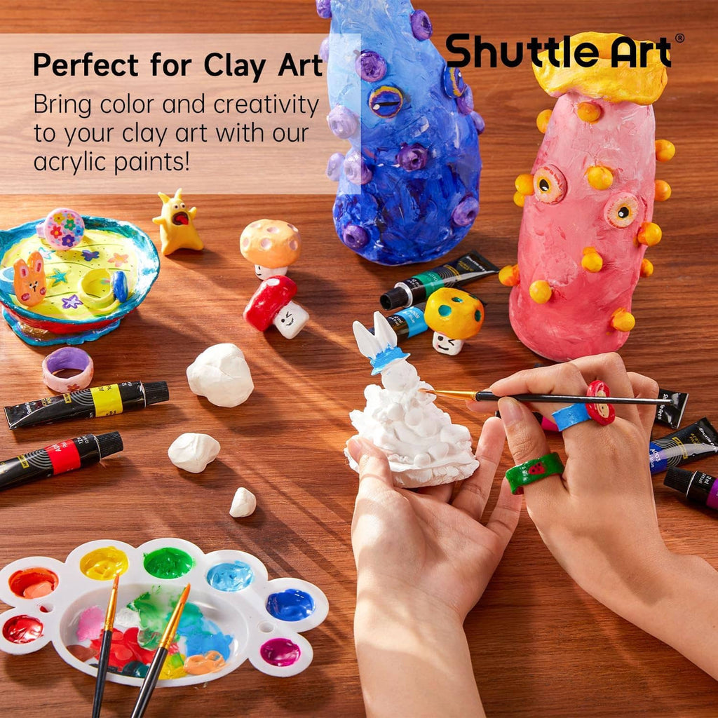 Acrylic paint tubes for clay art, with sculpted figurines and paint palette