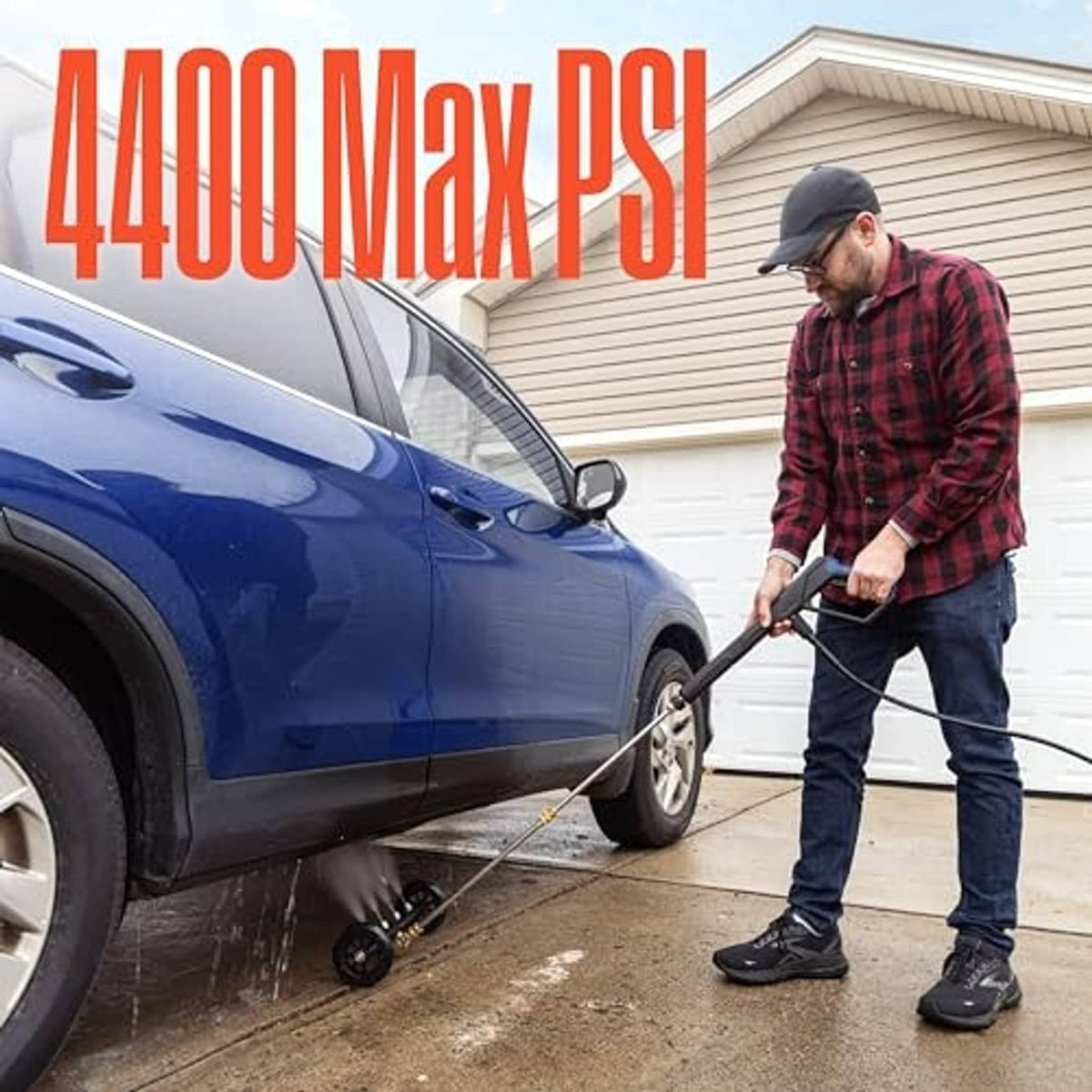 Undercarriage pressure washer cleaner aimed at a car near the front wheel