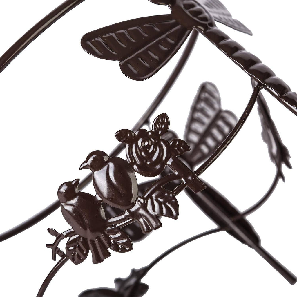 Metal gazing ball stand detail with twisted legs and dragonfly/butterfly motifs.