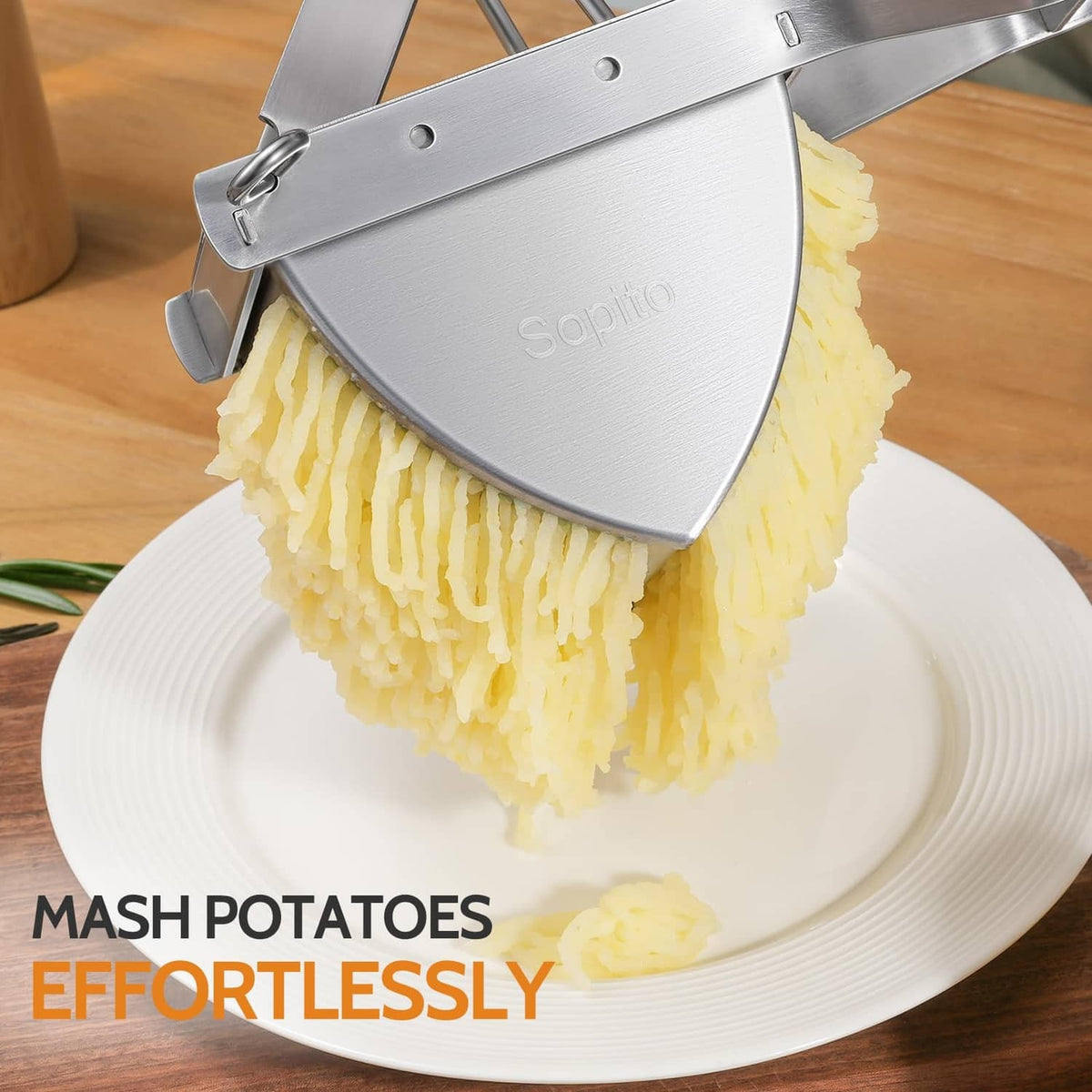 Stainless steel potato ricer pressing mashed potatoes from the perforated basket