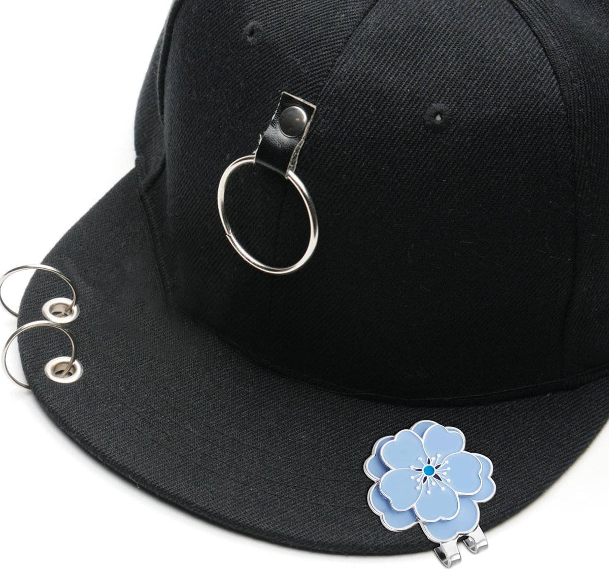 Blue flower golf ball marker attached to black cap with silver magnetic clip