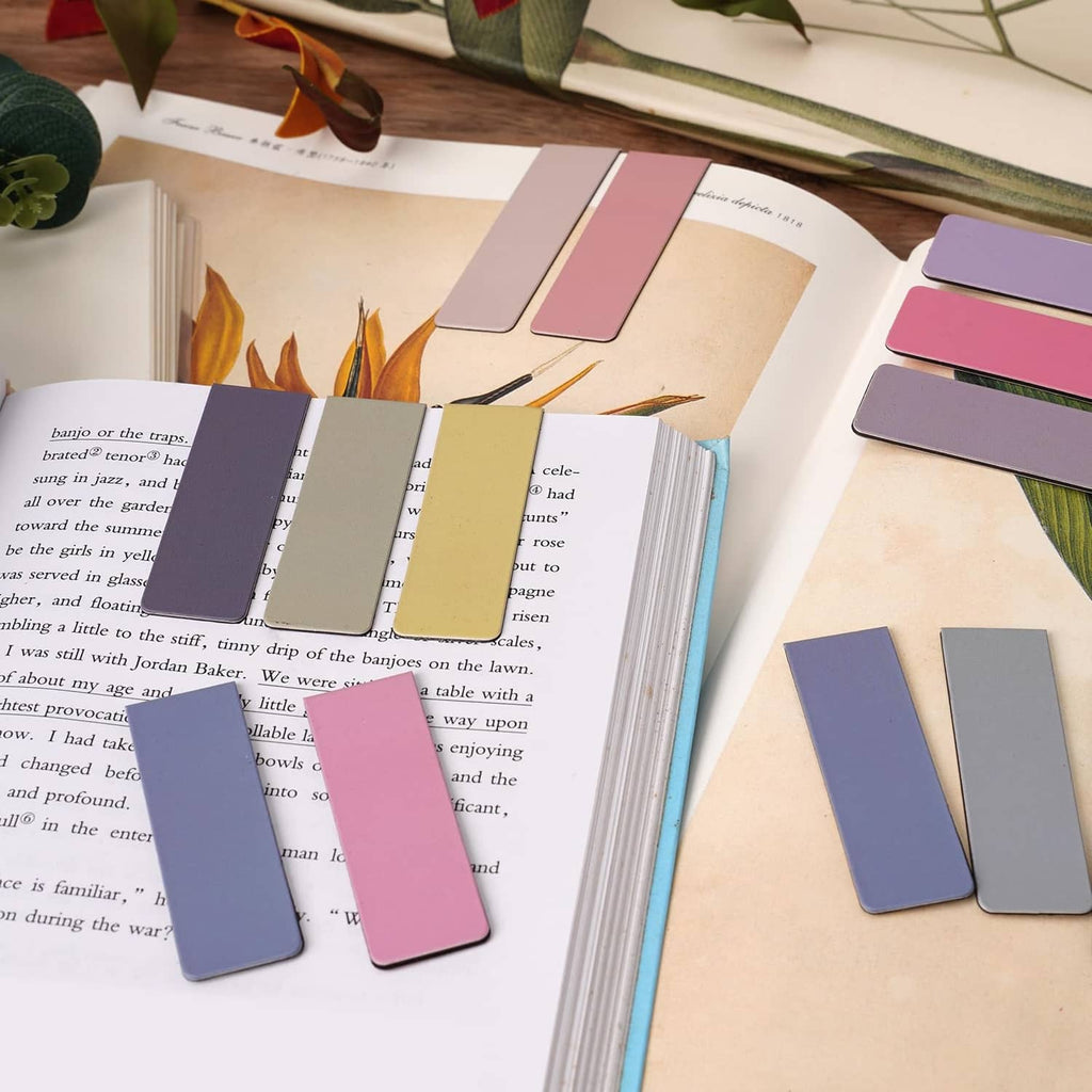 Magnetic bookmarks in pastel pink, purple, and blue on open book pages