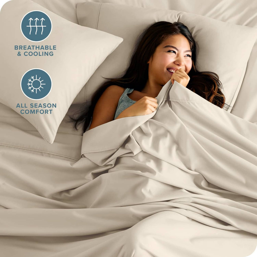 Beige sheet and pillowcase set with breathable, smooth fabric draped on bed