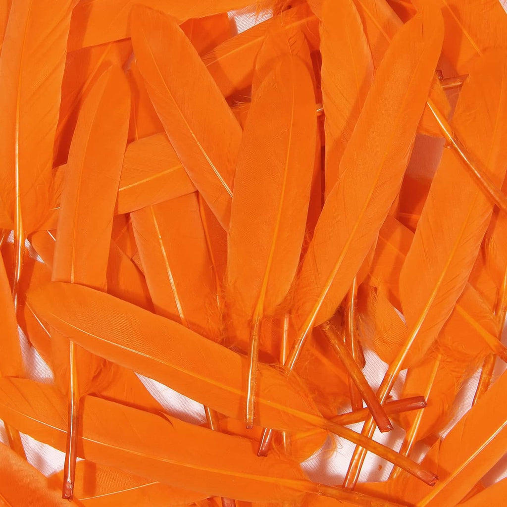 Orange goose feathers close-up pile, many narrow plumes and quills