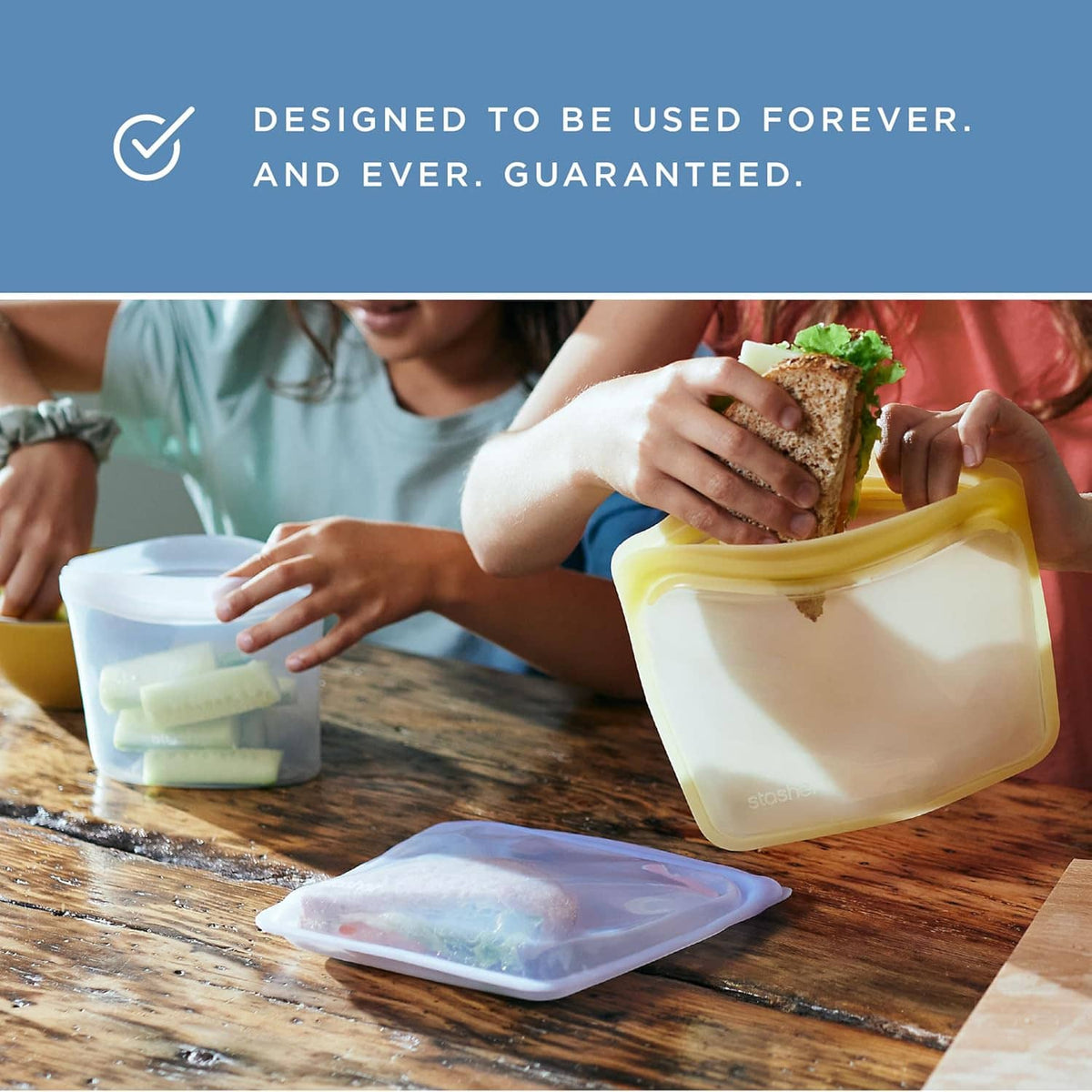 Reusable silicone storage bags for food, stacked on a wooden table