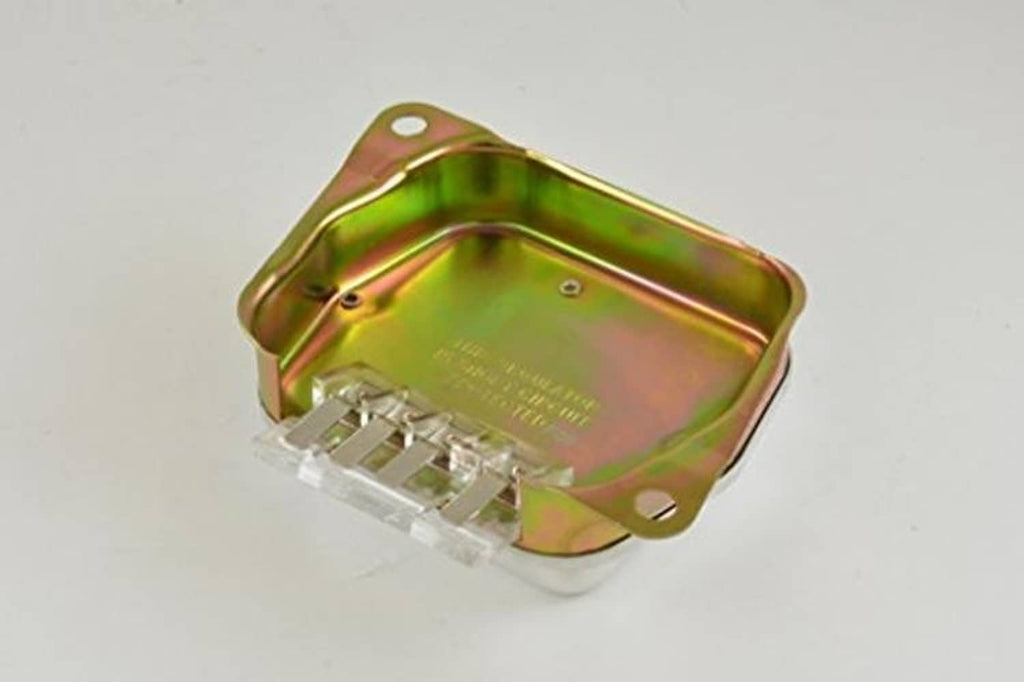 Alternator voltage regulator underside with exposed pins and green/gold mounting plate