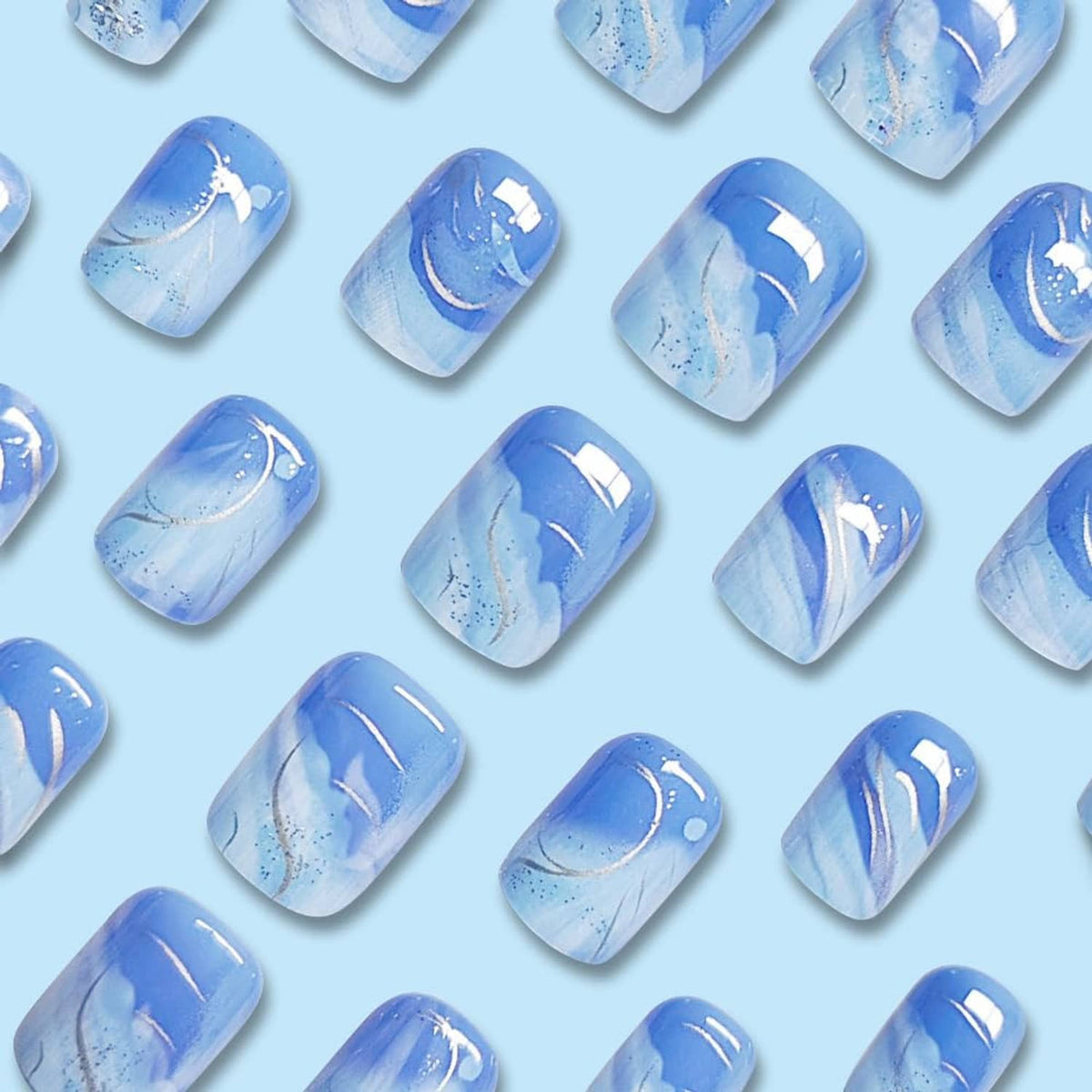 Short square press-on nails with blue gradient and white swoosh lines, sparkly finish