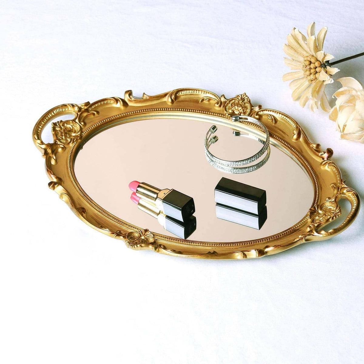 Gold oval decorative tray with mirror insert, lipstick, and flower embellishment