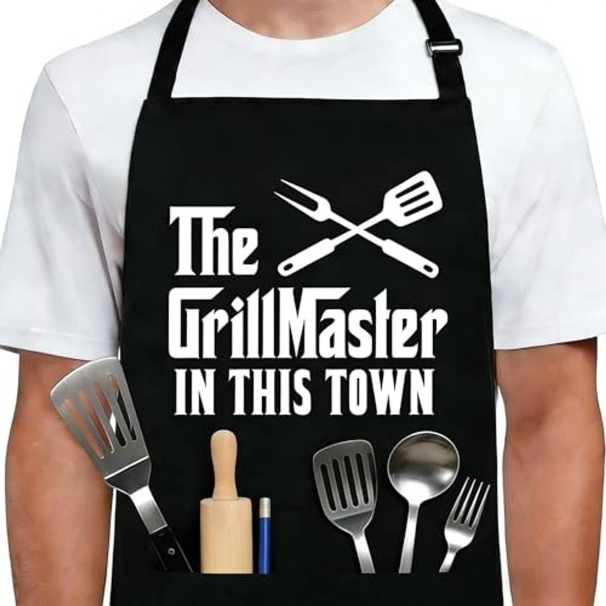 Black grilling apron front with grill-themed logo and utensil icons, over a white shirt.