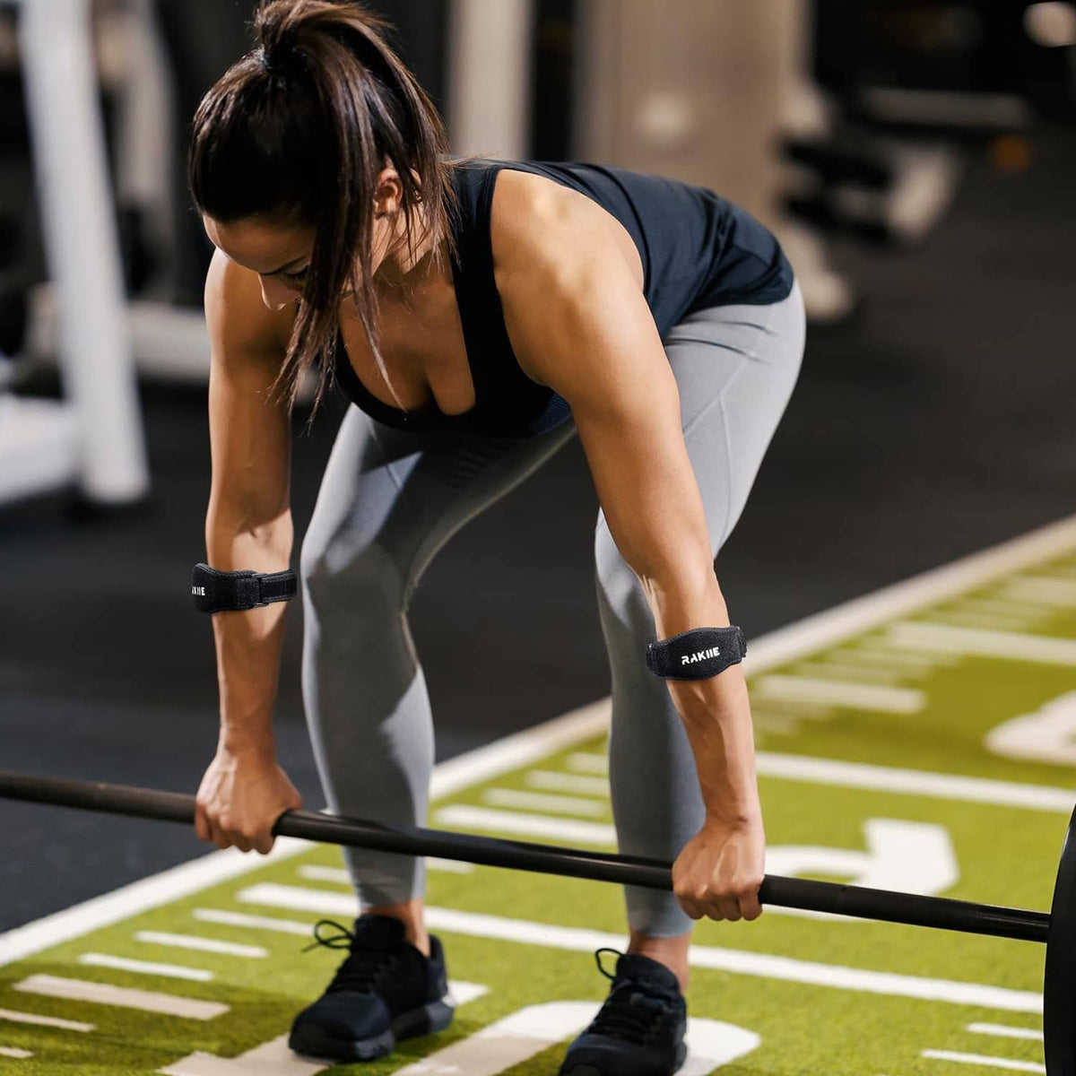 Black tennis elbow brace on arm during outdoor activity for targeted elbow support.