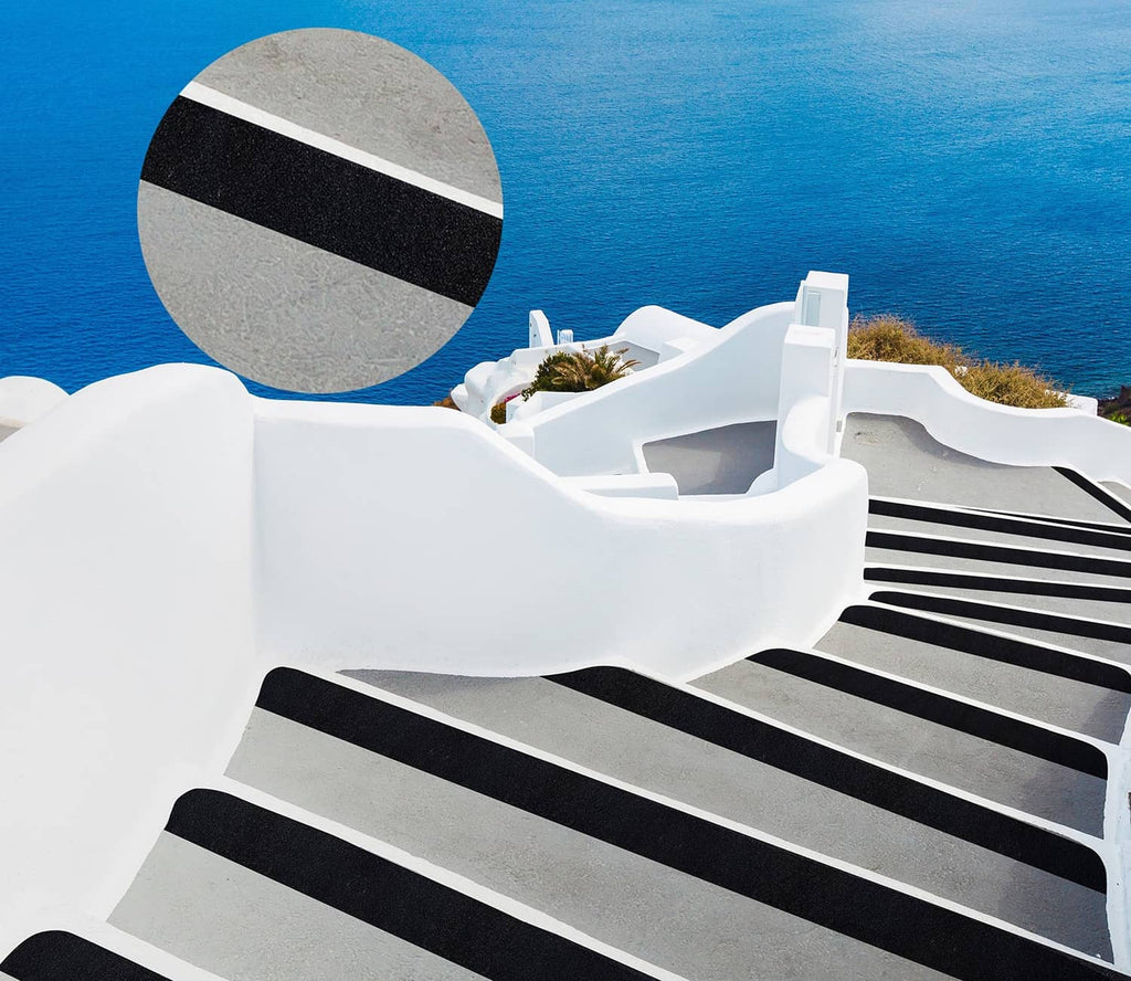 Anti-slip tape strips on white stair steps, dark gray traction bars