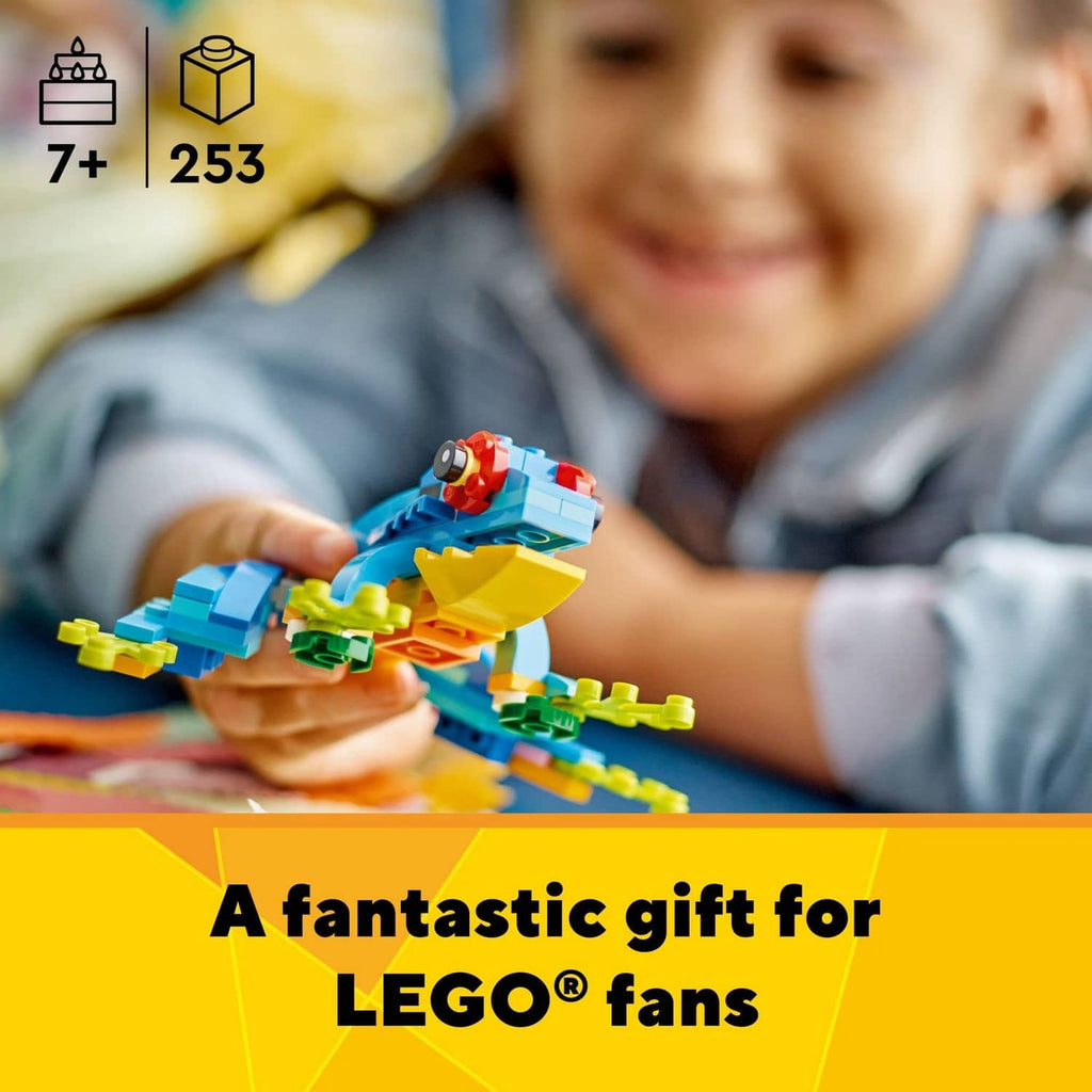 LEGO 3-in-1 parrot model in a child’s hands, blue and yellow bird with green pieces