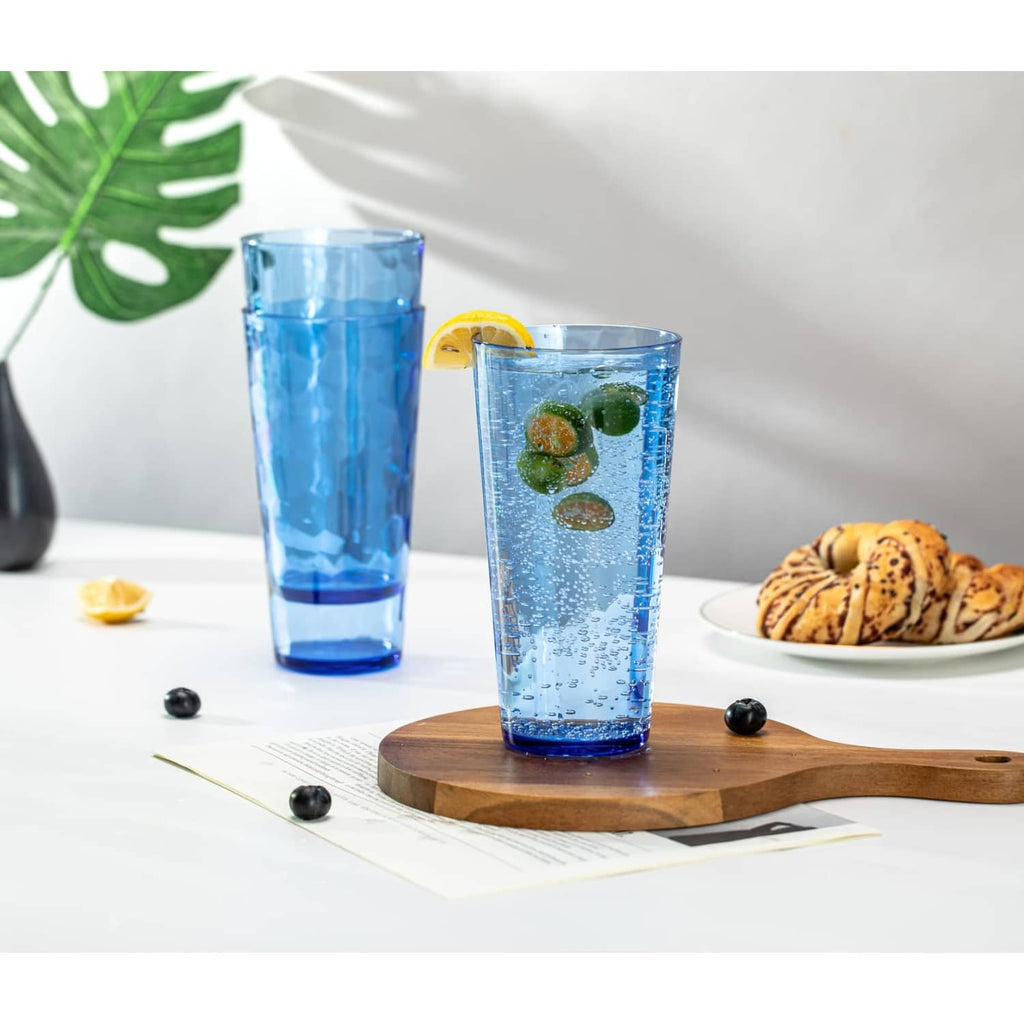 Set of blue hammered highball tumblers with ice and lemon slices on table