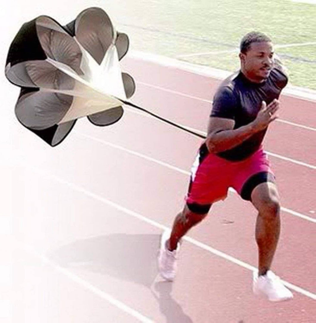 Runner pulling a black-and-gray parachute resistance chute for sprint training