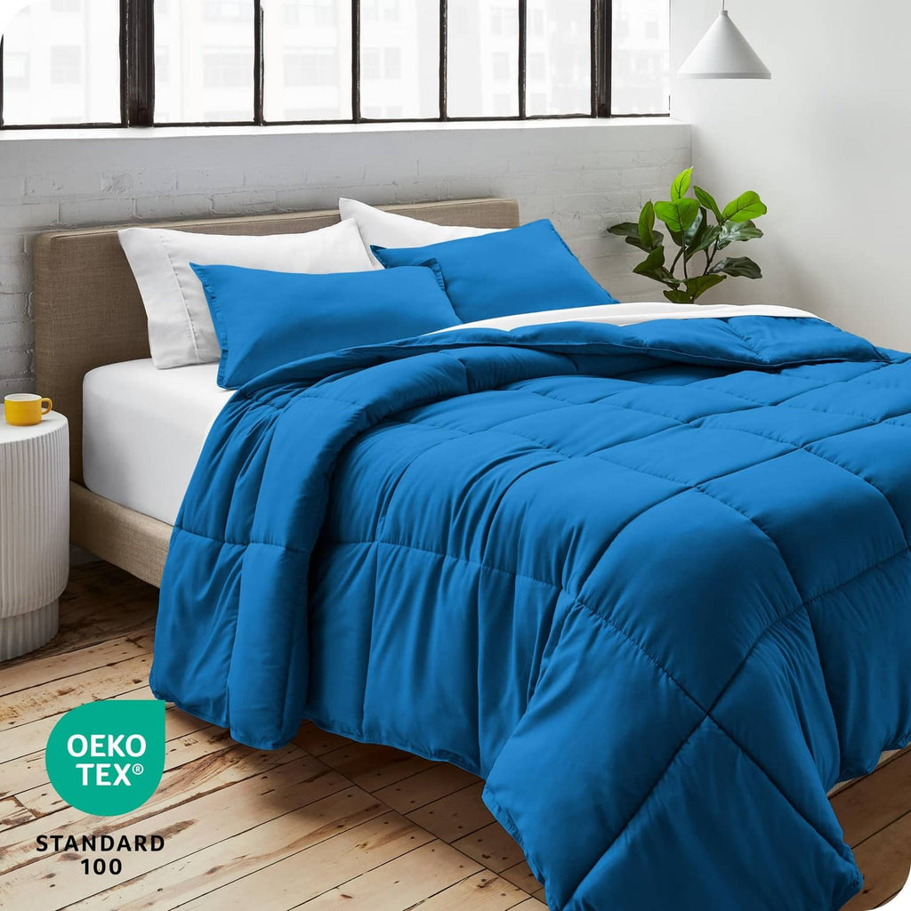 Blue comforter and pillow shams set on bed with matching pillows