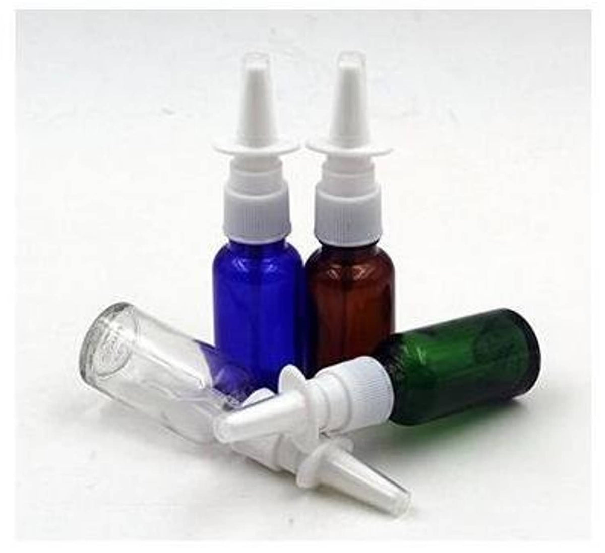 Refillable nasal bottles in blue, amber, and green glass with white pump nozzles, set
