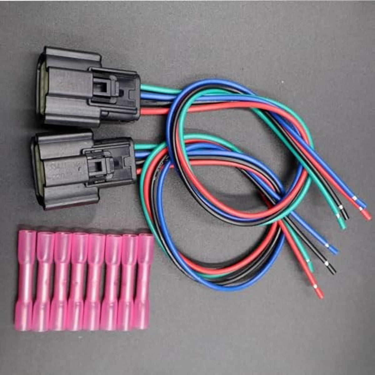 Two headlight wiring connectors with multi-pin plugs, colored wires, and pink terminals