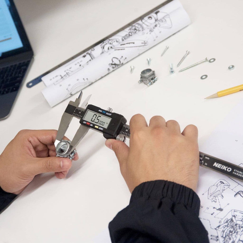 Digital caliper in use, hand holding tool and measuring small metal components
