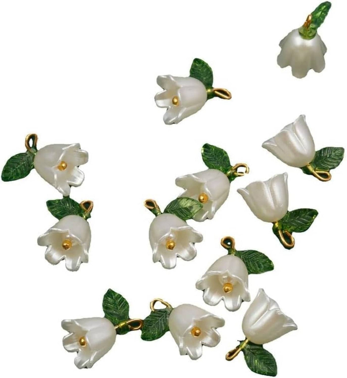 White bell orchid pendant beads with green leaves and gold loop rings, scattered view