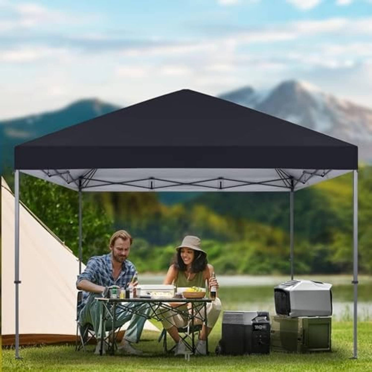 Black pop-up canopy top outdoors over metal legs, covering a picnic table