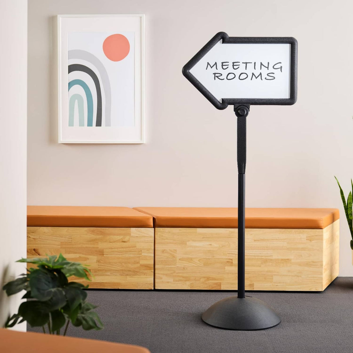 Black directional arrow sign with "MEETING ROOMS" board text