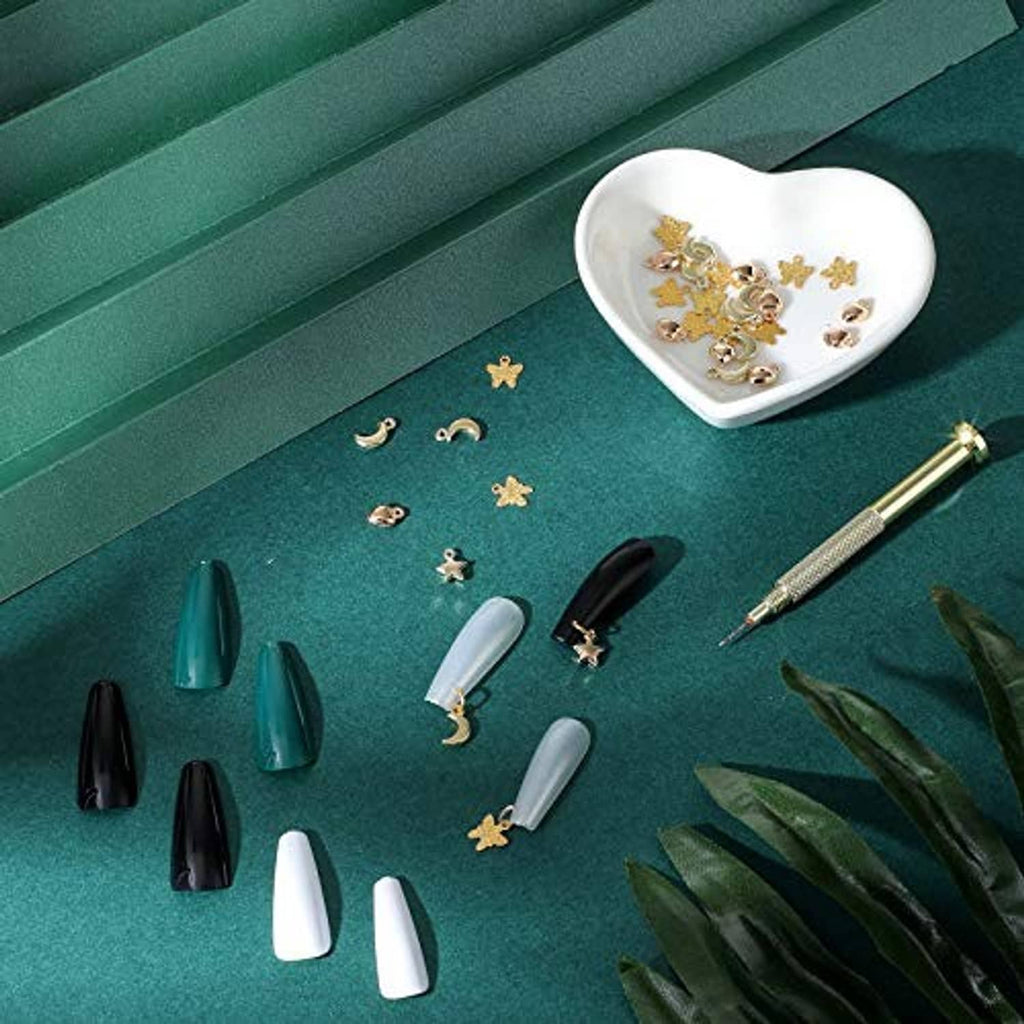 Gold nail jewelry charms with crescent, star, and heart shapes with a piercing tool