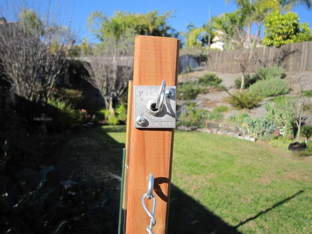 Wire anchor vise on wooden post with metal clips holding fence wire