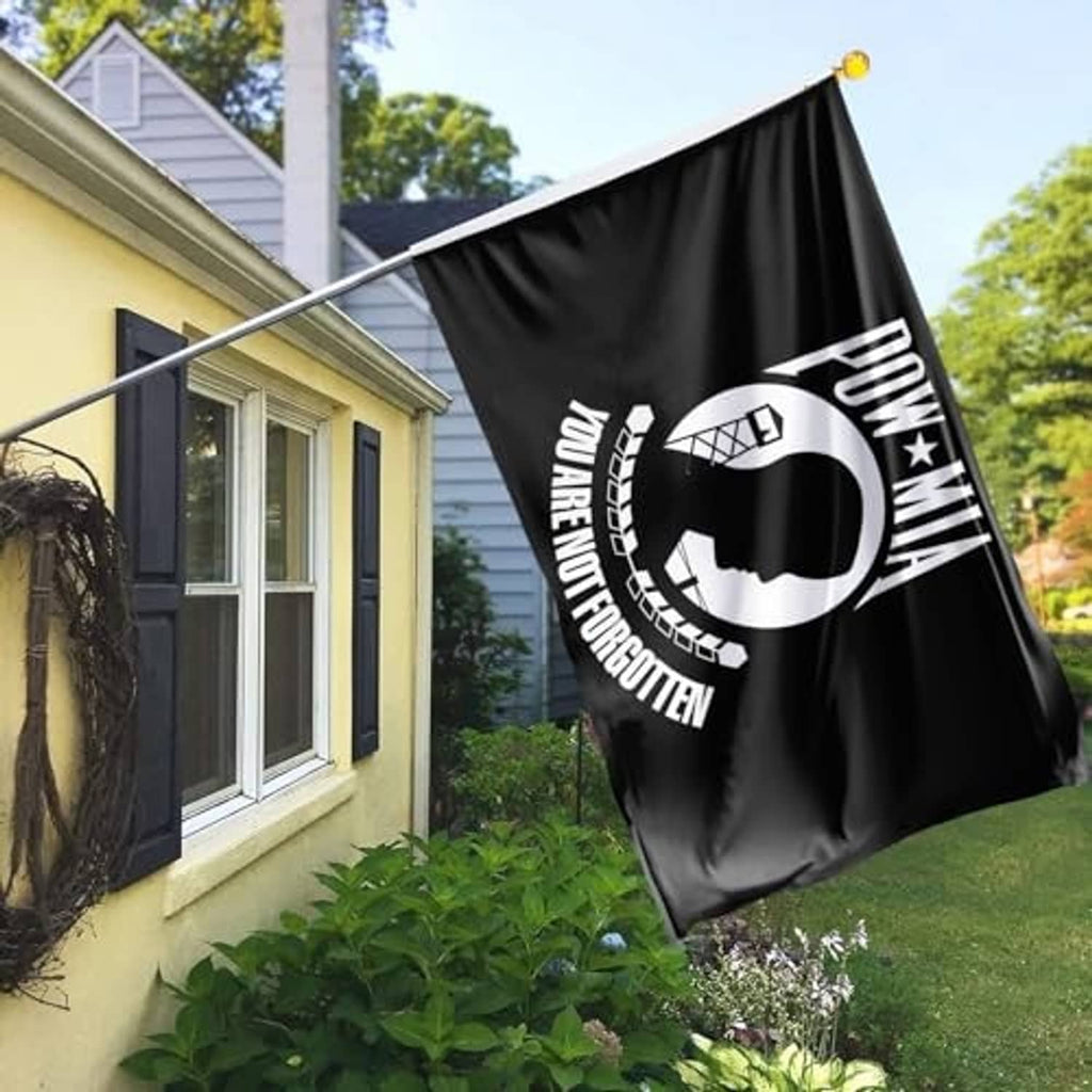 Black POW*MIA outdoor flag waving outdoors with circular emblem and “You are not forgotten”