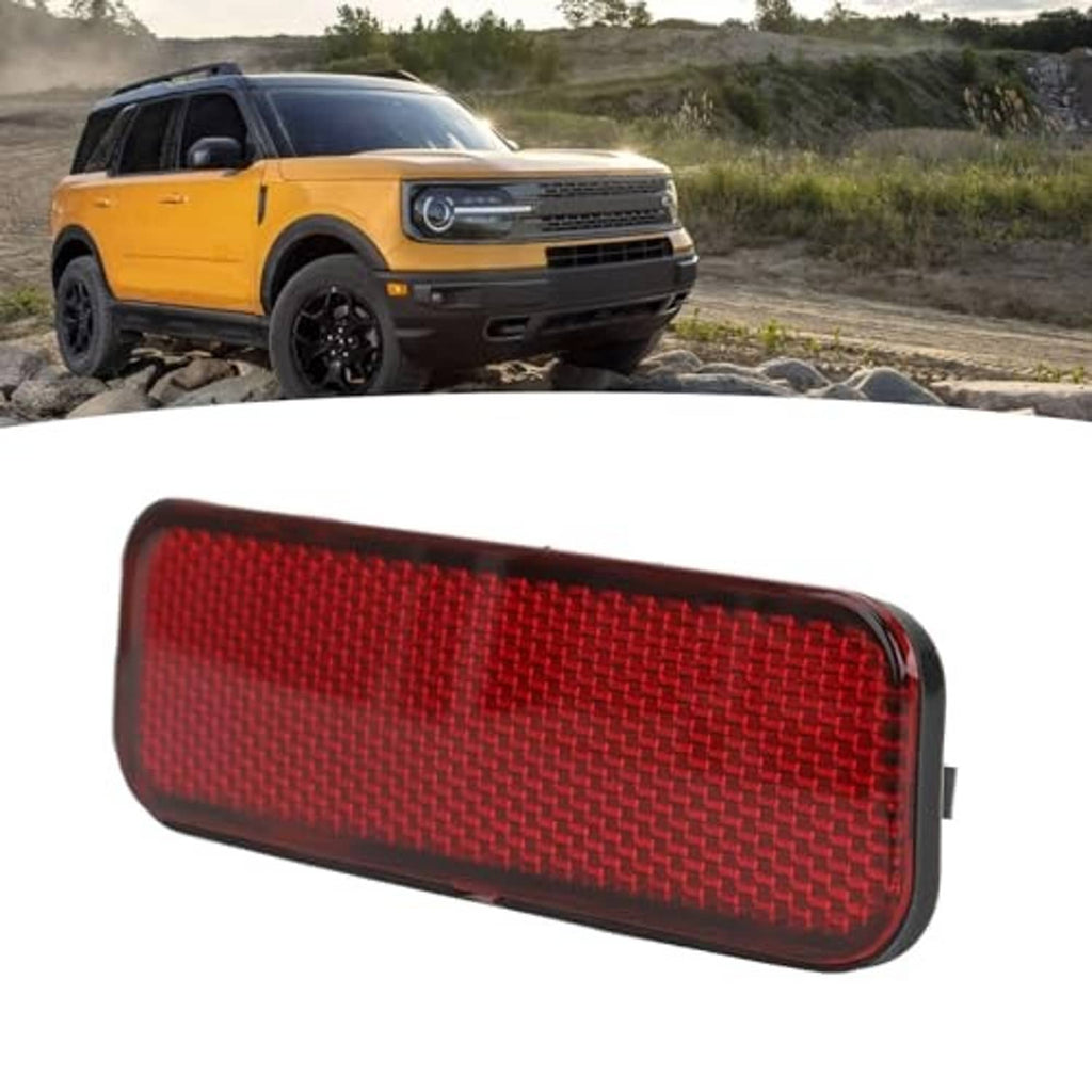 Red rear bumper reflector with textured pattern and dark frame, angled view