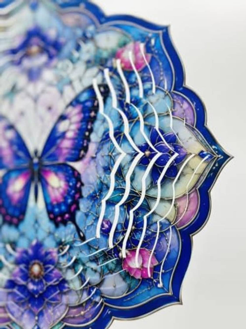 Close-up of purple-blue butterfly wind spinner with wavy metallic fan blades