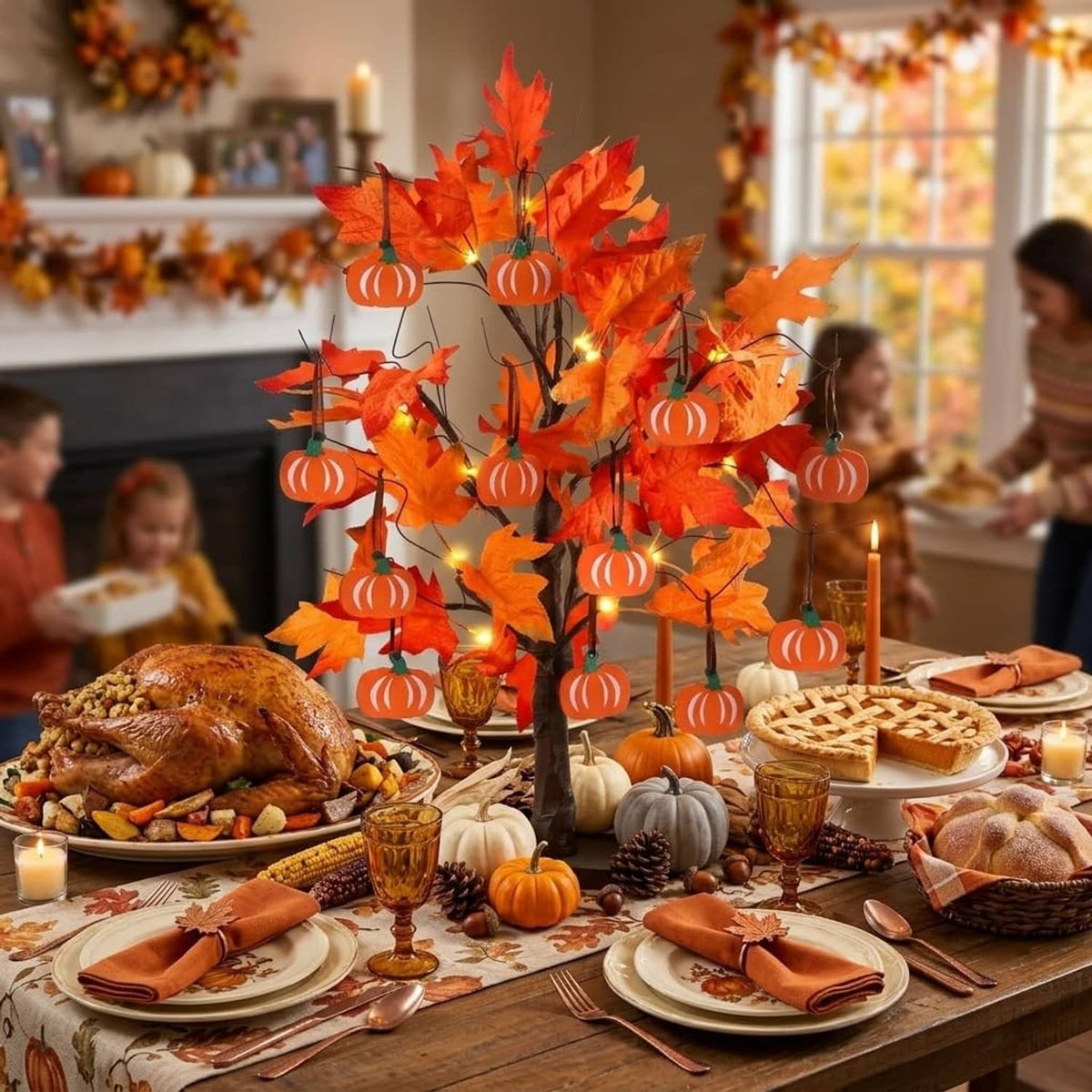 Fall centerpiece tree with orange maple leaves, warm LED lights, and hanging pumpkin ornaments