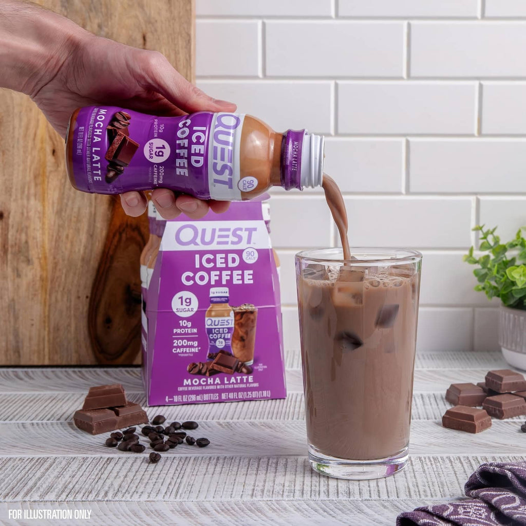 Hand pouring mocha latte iced coffee from bottle into a clear glass
