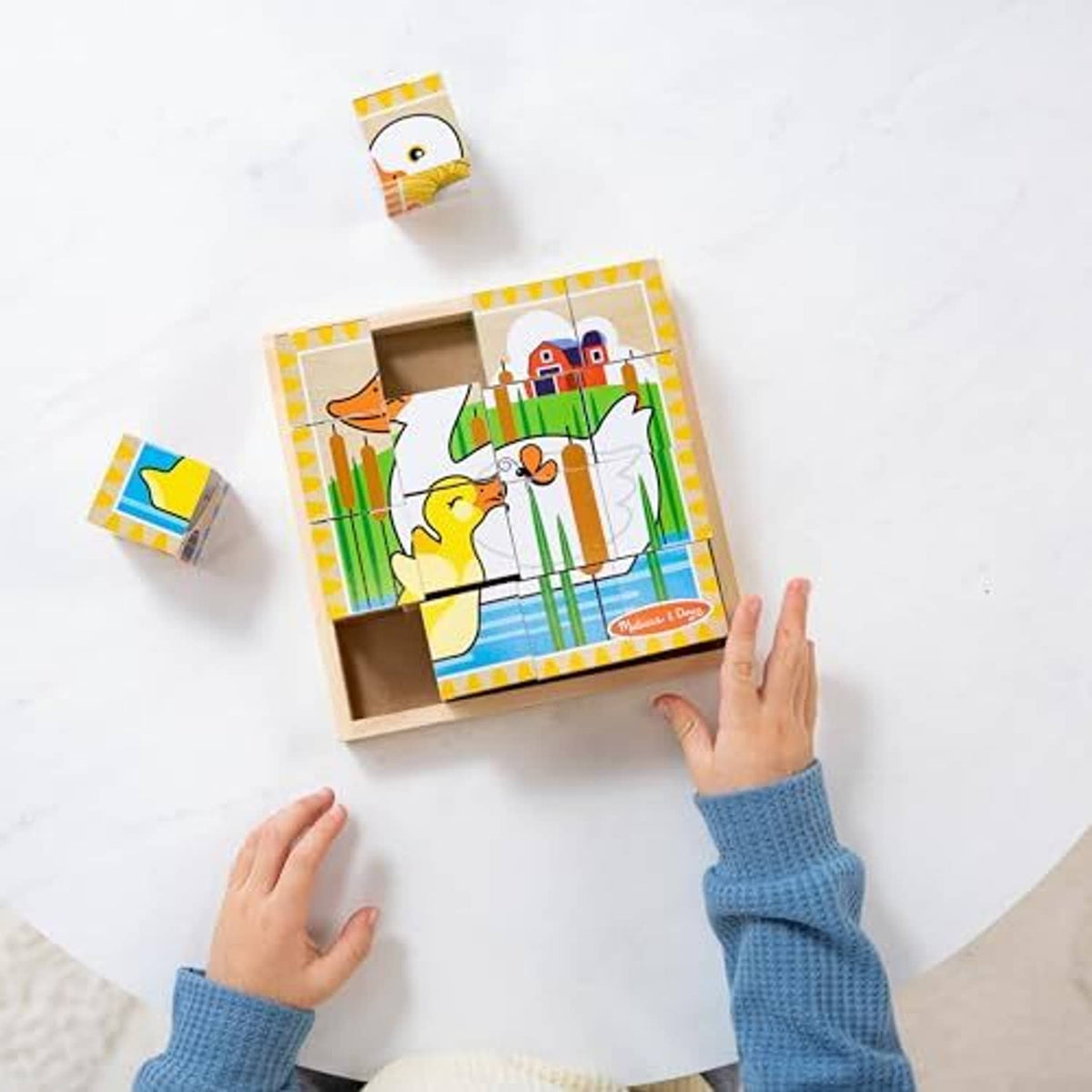 Wooden cube puzzle farm set with tray and loose cubes on a tabletop