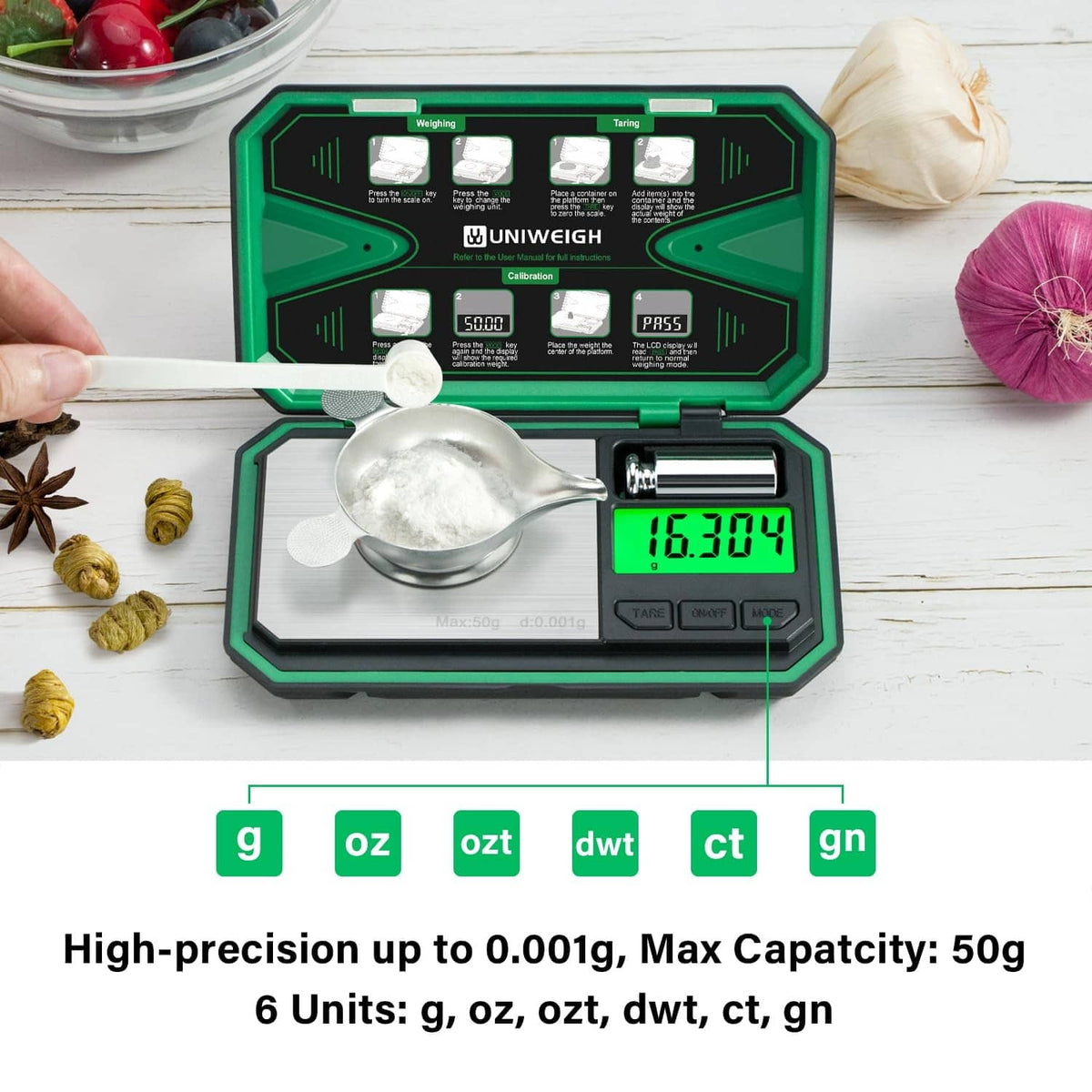 Milligram scale with silver weighing pan, green backlit LCD, and open protective case