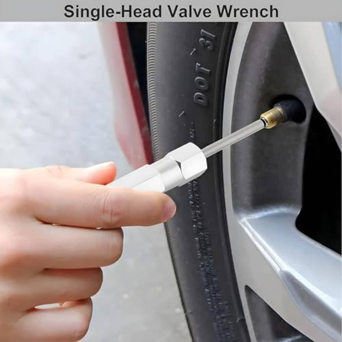 Hand using single-head valve wrench at a tire valve, white handle and metal rod