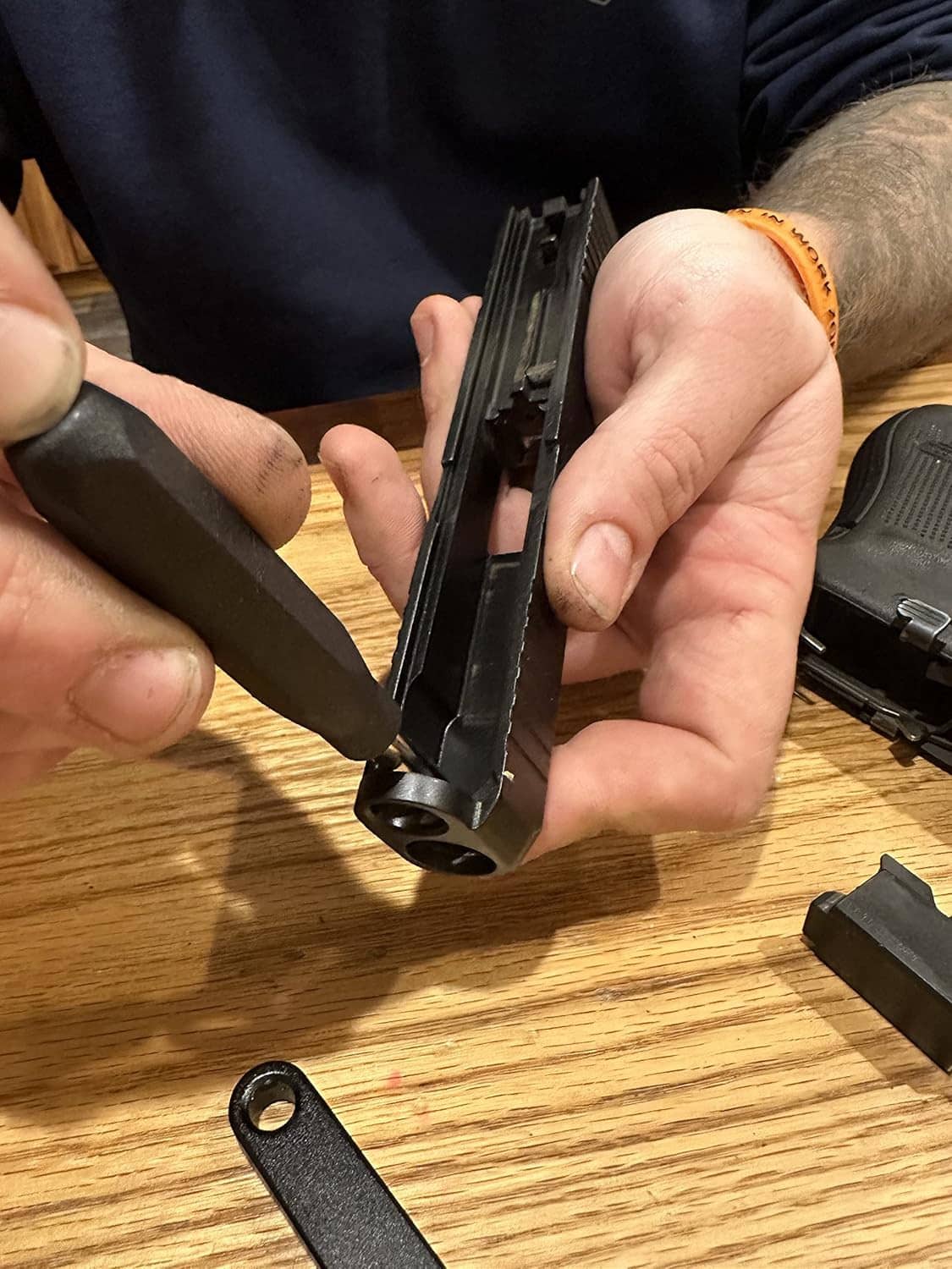 Black pistol tool disassembly stand with metal pins and grips