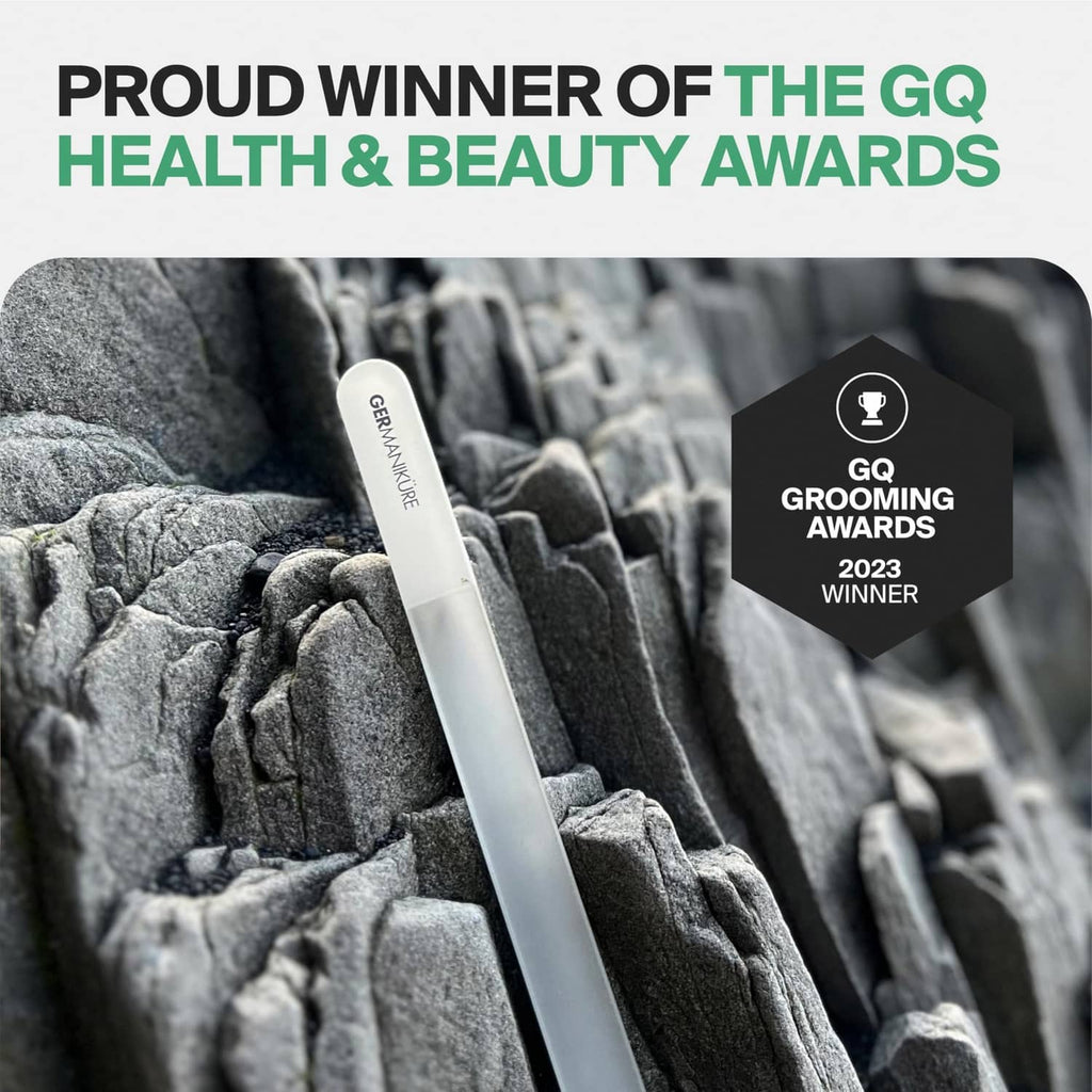 Gray glass nail file resting on textured fabric