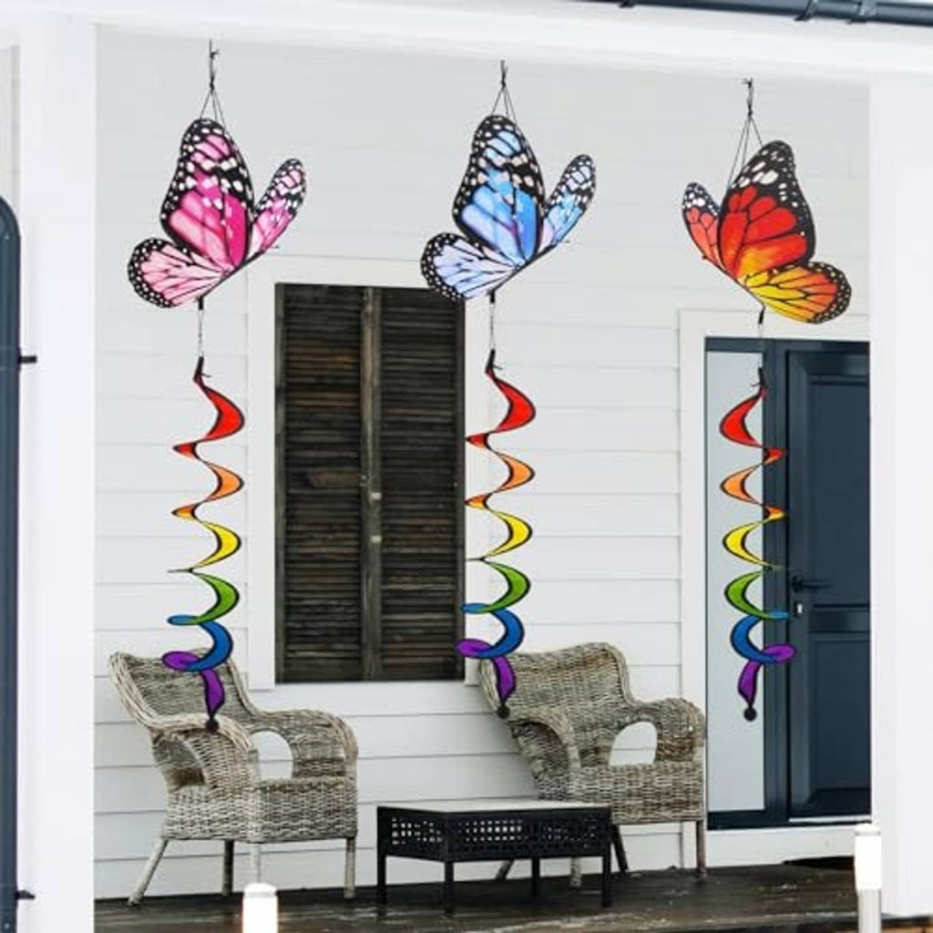 Three butterfly wind spinners hanging outside with multicolor spiral ribbon tails